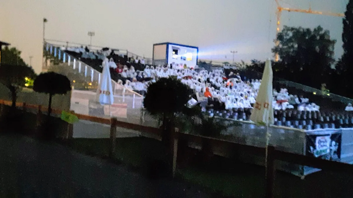 Publikum mit weissen Pelerinen im strömenden Regen am Open-Air-Kino in Uster 2023.